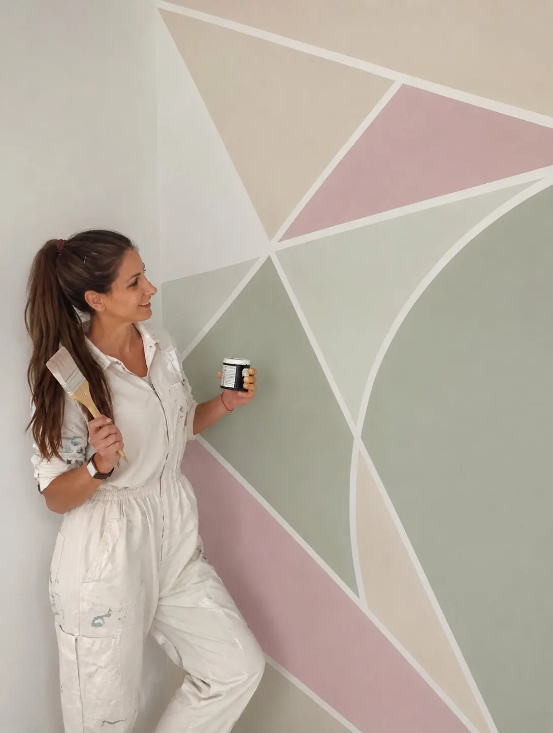 Anita Kiss standing before a geometric painted wall in cream, blush and sage